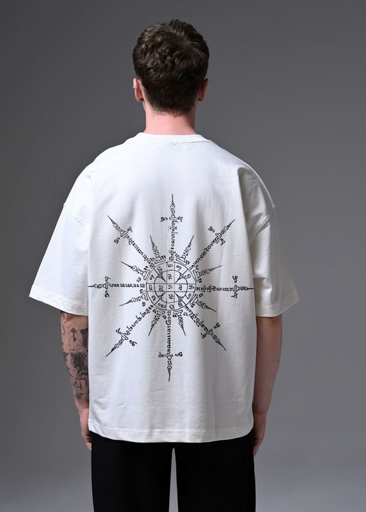 Person wearing a white t-shirt with a black geometric design on the back against a gray background